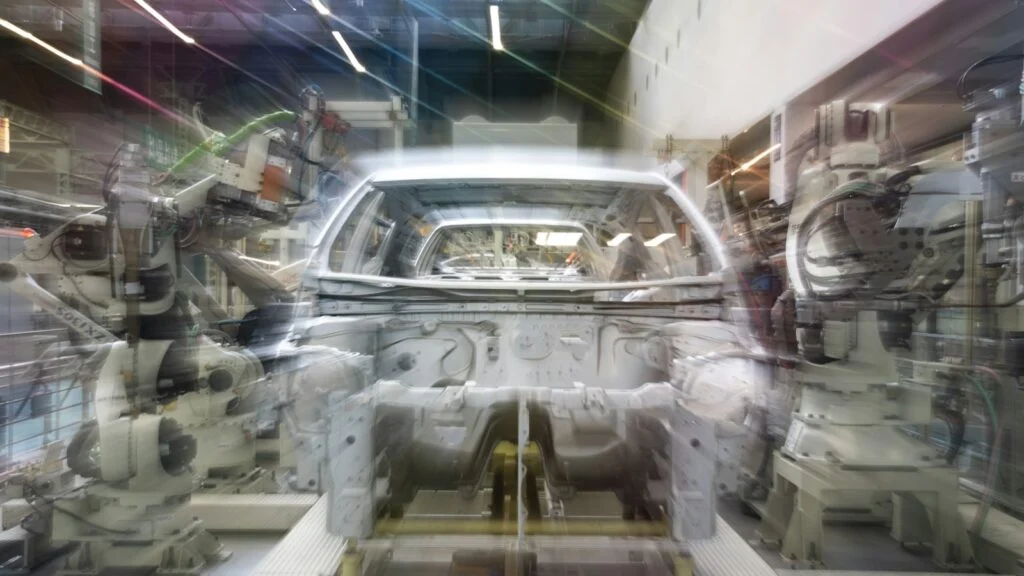 Car assembly line with robotic arms and a car body