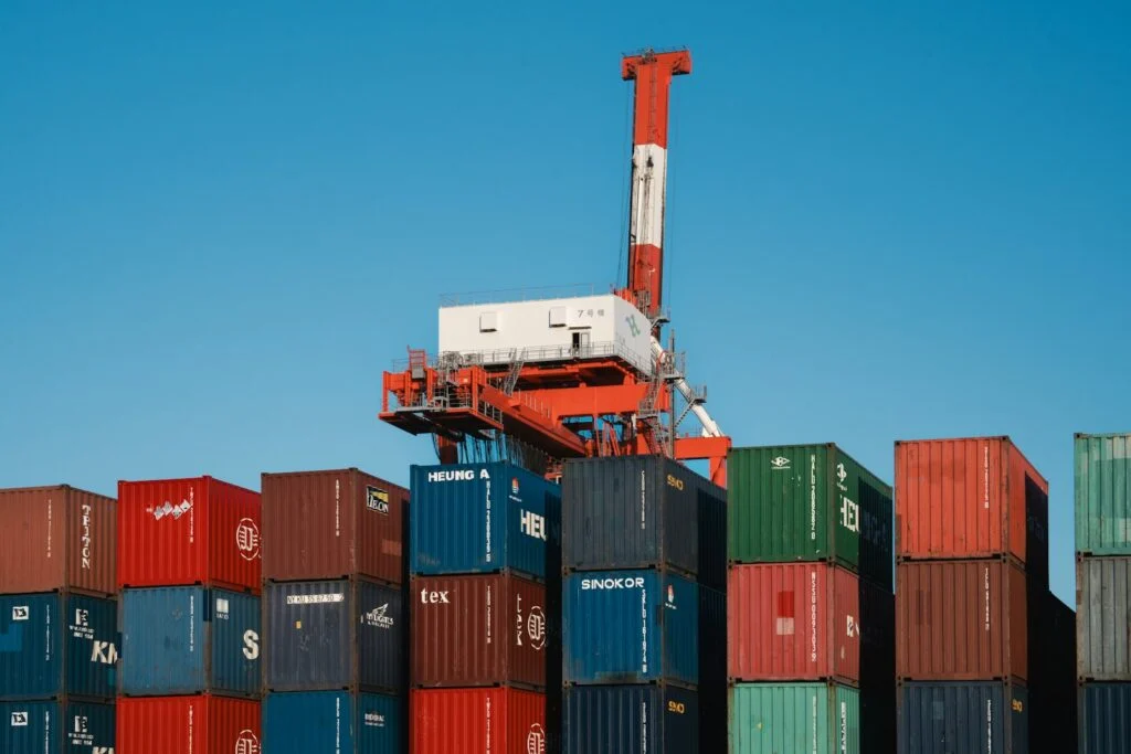 Gantry crane above a large stack of colourful shipping containers
